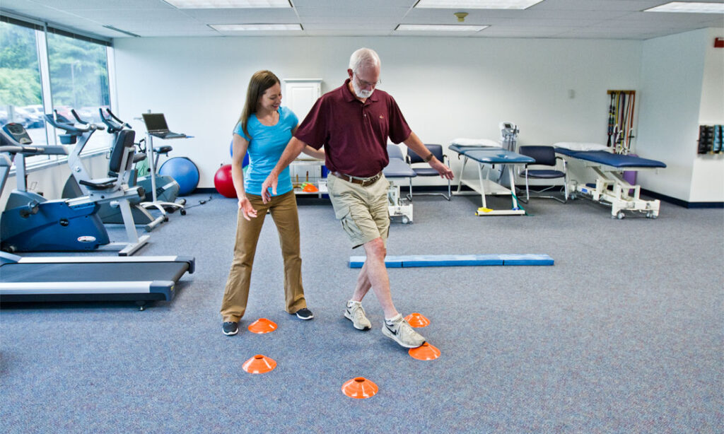 Neurological physiotherapy after a stroke — patient practising walking with physiotherapist support
